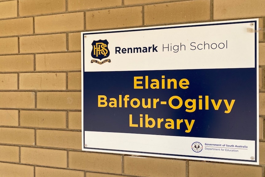 A sign that reads "Elaine Balfour-Ogilvy Library", attached to a brick wall.