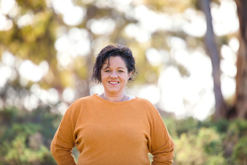 A woman standing in bushland.  