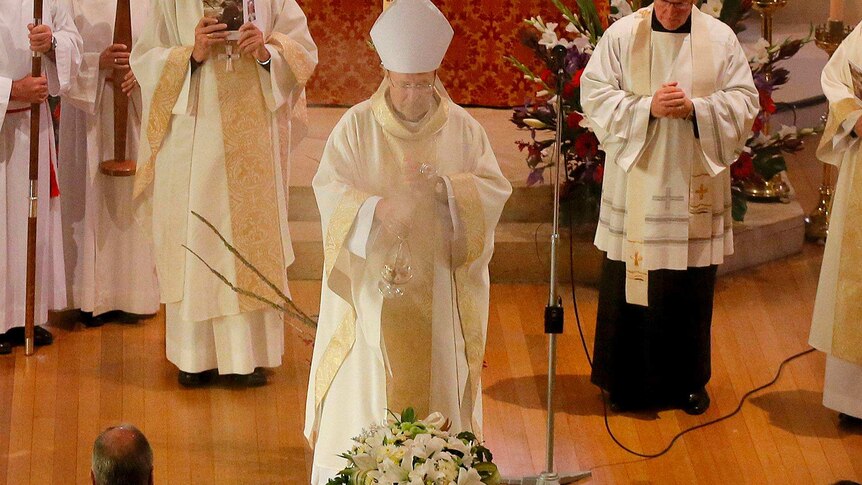 Archbishop of Hobart, Julian Porteous, wafts incense over the coffin of former senator Brian Harradine.