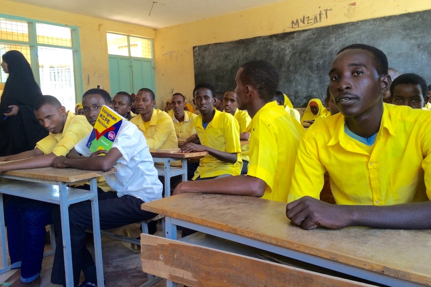 Boys sit at desks in a school classroom in Dadaab