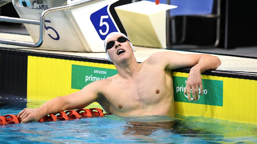 Australian swimmer Mack Horton, in cap and goggles, looks tired in the pool after the 400m freestyle final at the Olympic trials