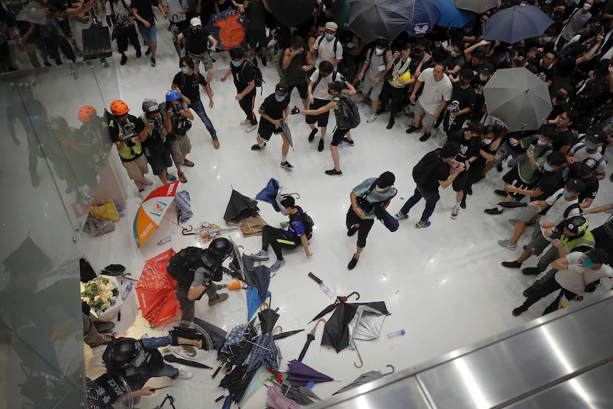 Protesters scuffle with policemen inside a shopping mall.