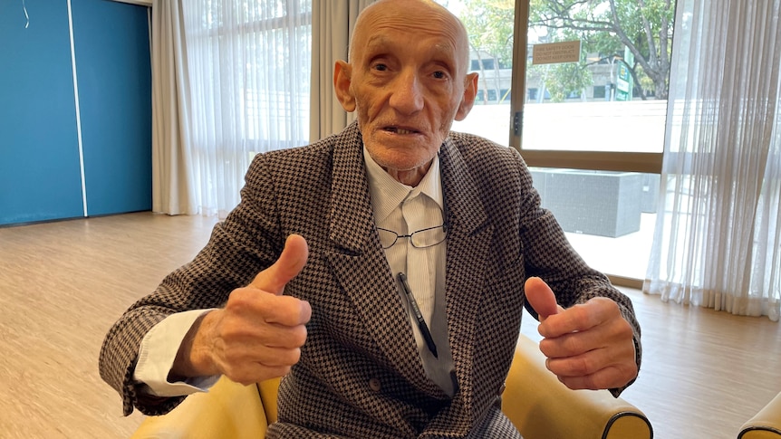 Elderly man with both of his thumbs up. 