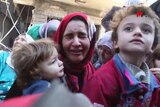 A women carries her child and cries after fleeing an IS held neighbourhood