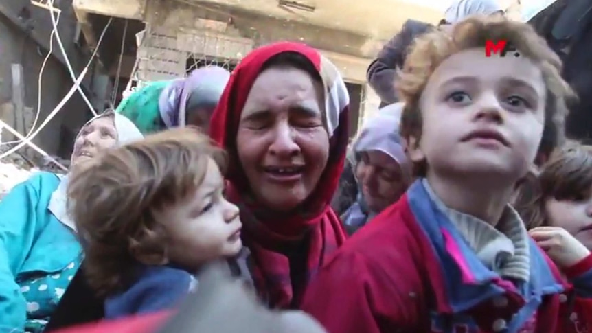 A women carries her child and cries after fleeing an IS held neighbourhood