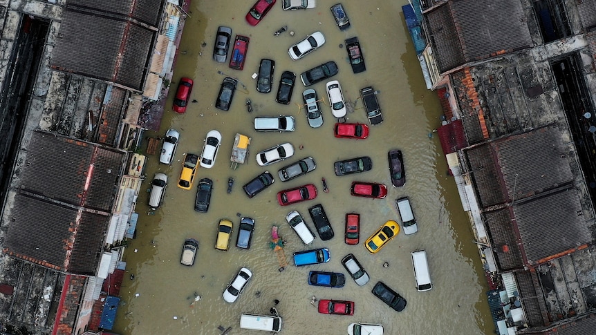 Aerial view shows vehicles and buildings inundated by floods.