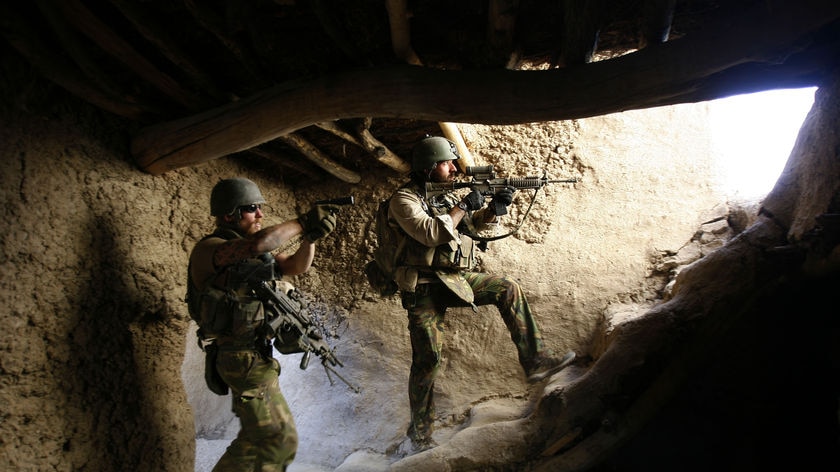 Dutch soldiers search a house