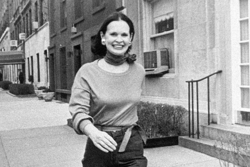 Gloria Vanderbilt smiles and walks down a New York street