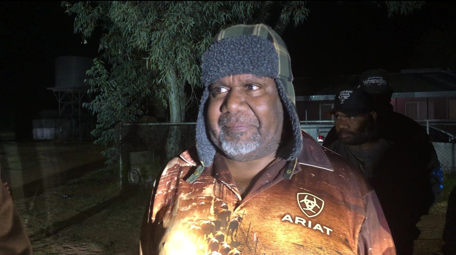 An Indigenous man speaking to a journalist.
