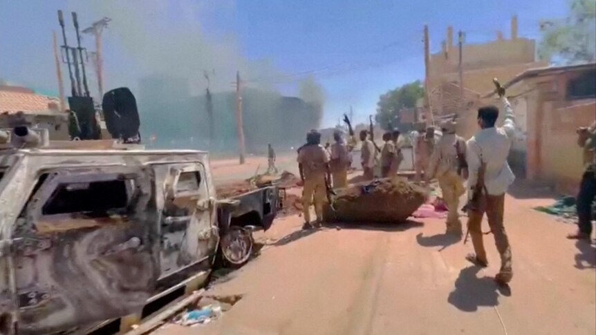 RSF fighters stand near the damaged Air Defence Forces command centre in Khartoum.