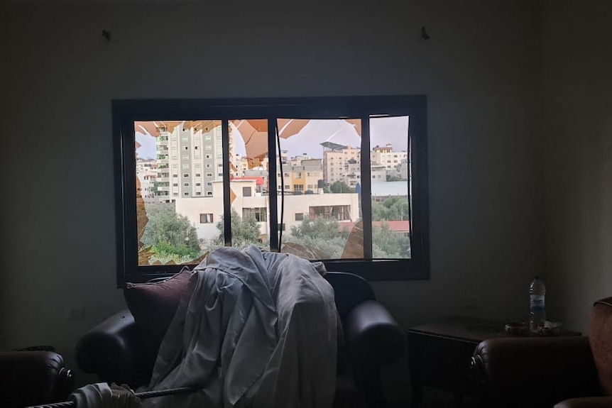 A broken window is in view from inside a loungeroom in Gaza.