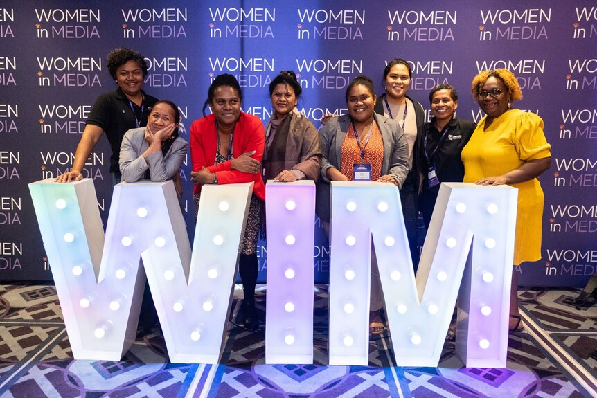 Pacific women standing in front of Women in Media sign