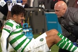 Daniel Arzani is treated by medical staff after injuring his knee in Celtic's game against Dundee.