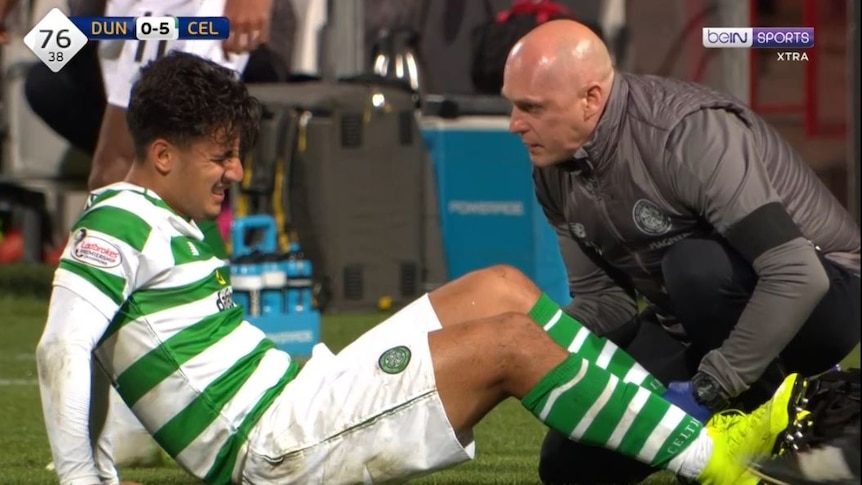 Daniel Arzani is treated by medical staff after injuring his knee in Celtic's game against Dundee.