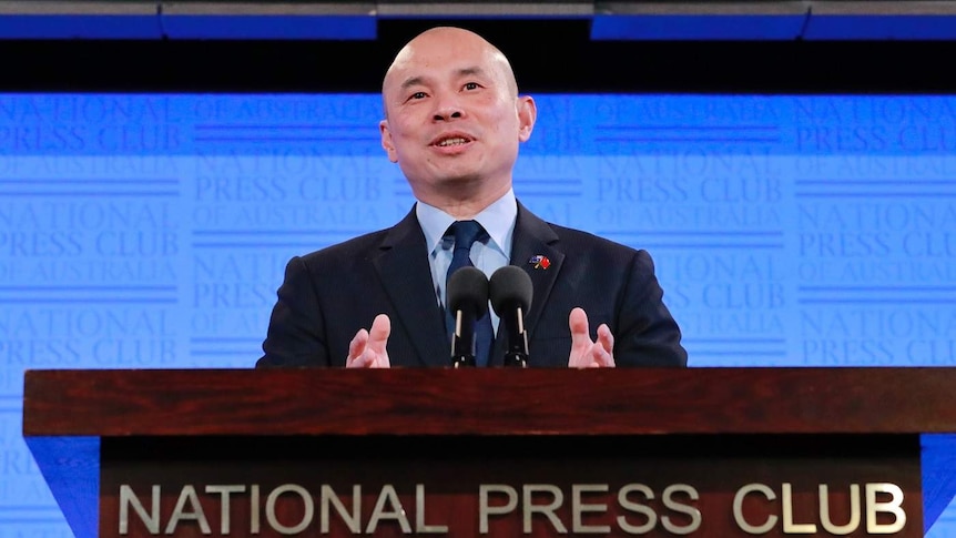 Wang Xining stands at the National Press Club podium.