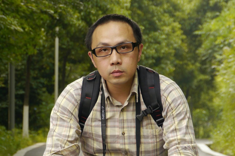 A man look at camera, sitting in the bush