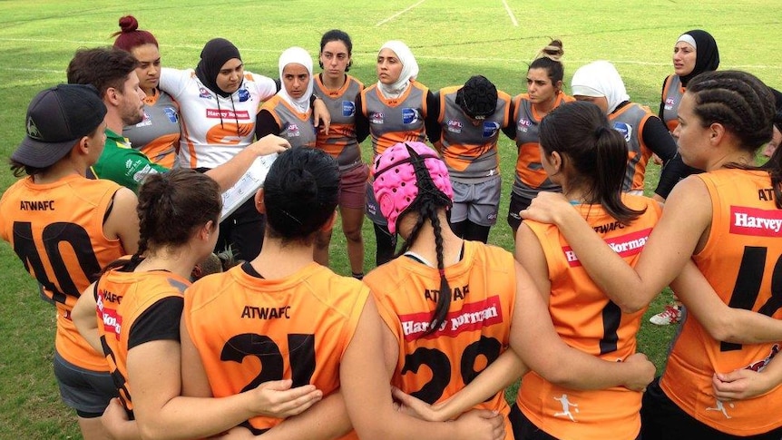 Auburn Giants women's multicultural AFL team in a huddle at a game