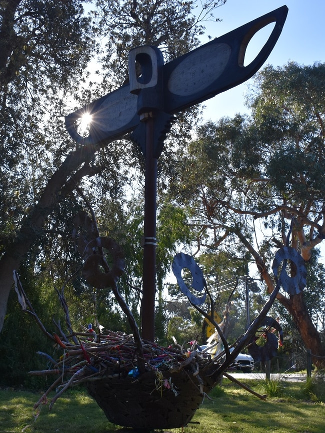 An eagle-shaped sculpture sits atop a basket made from recycled materials.