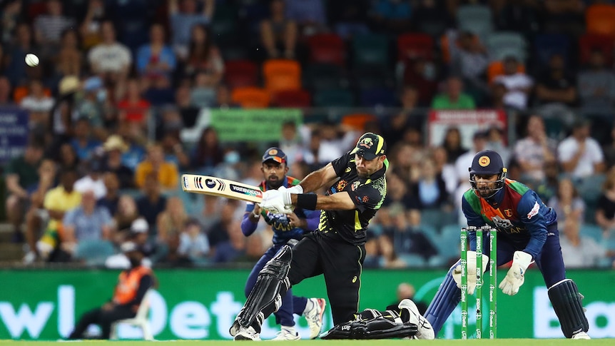 Australian batsman Glenn Maxwell gets down on one knee to smash a six over the fence on the leg side.