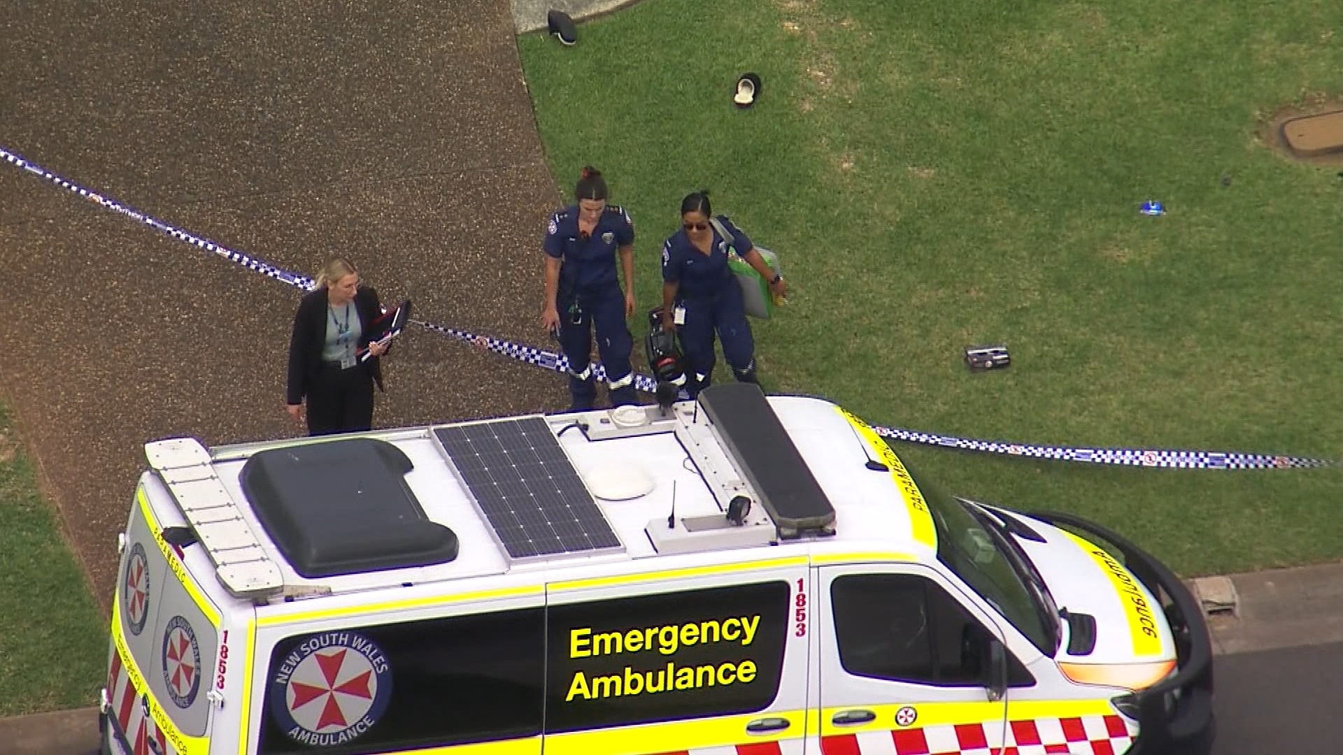 Ambulance with police tape and emergency responders