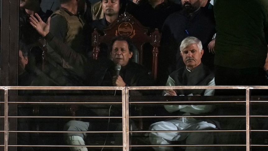 Imran Khan delivers an address while seated.