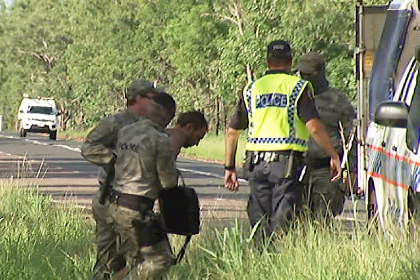 Police escort Timothy Curtis to a police van, after he was captured near Batchelor