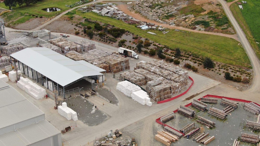 An aerial view of recycled paper waste stacked in rows.