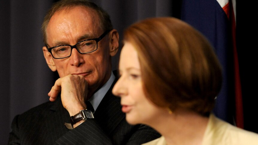 Former NSW premier Bob Carr listens at a press conference with Prime Minister Julia Gillard in Canberra, Friday, March 2, 2012.