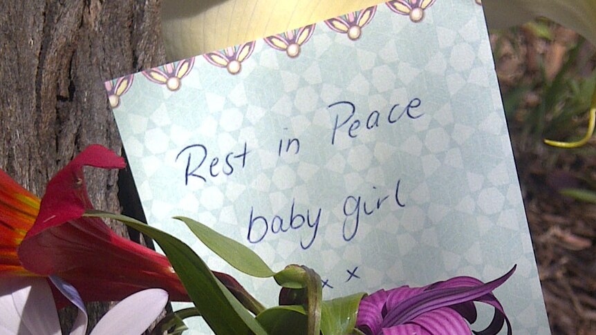 Neighbours have left flowers, cards and toys in a park where the body of  a newborn girl was found in Tasmania.