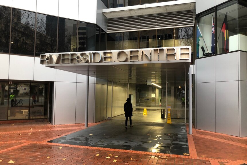 The entrance to the Riverside Centre with a man walking in