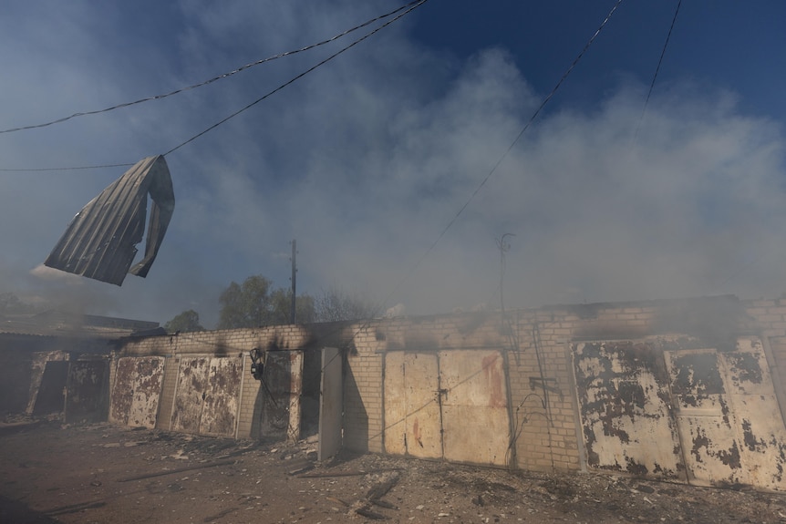 A garage burns following a military strike on a garage in Lyman, Ukraine
