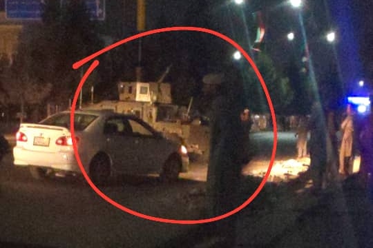 A tank is seen in the street at night.