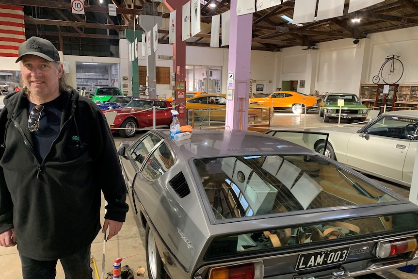 Man stands in front of futurisitic looking sports hatch with glass boot