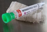 A vial rests on a gause swab with monkeypox written on it