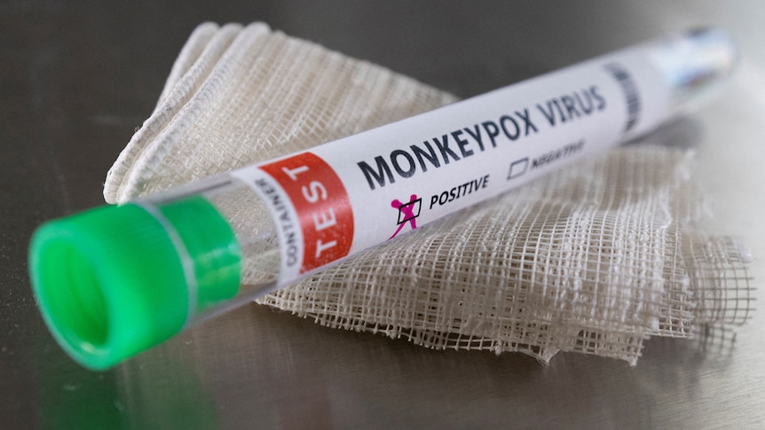 A vial rests on a gause swab with monkeypox written on it