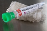 A vial rests on a gause swab with monkeypox written on it