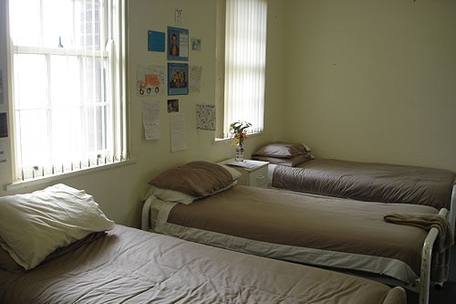 A room with several beds in it. 