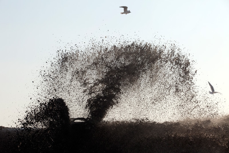 Wet sand being sprayed into the air.