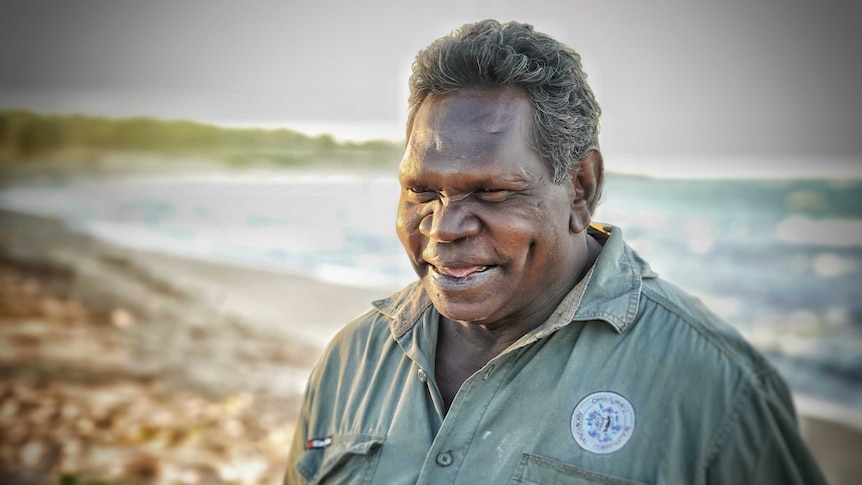 Mandaka Marika smiles standing on a beach.