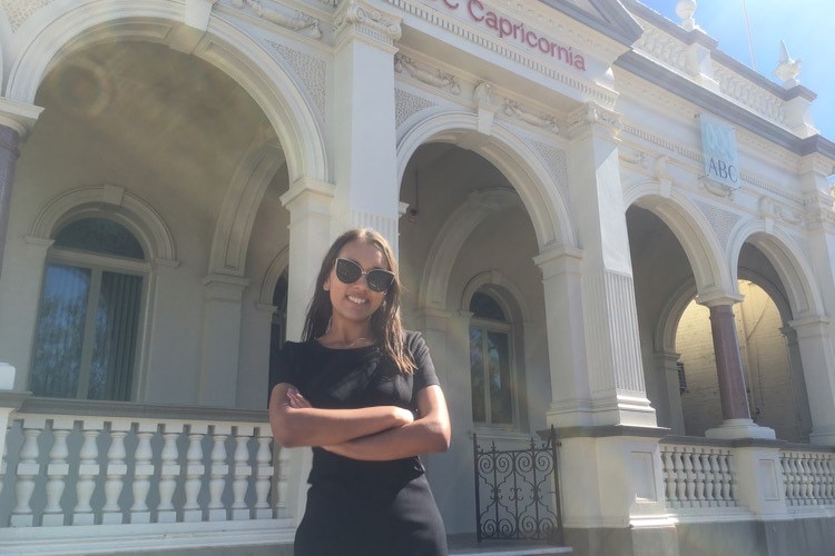 Isabella Higgins standing in front of the ABC Capricornia building with her arms crossed.