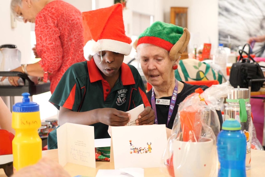 Children and residents exchange gifts and cards