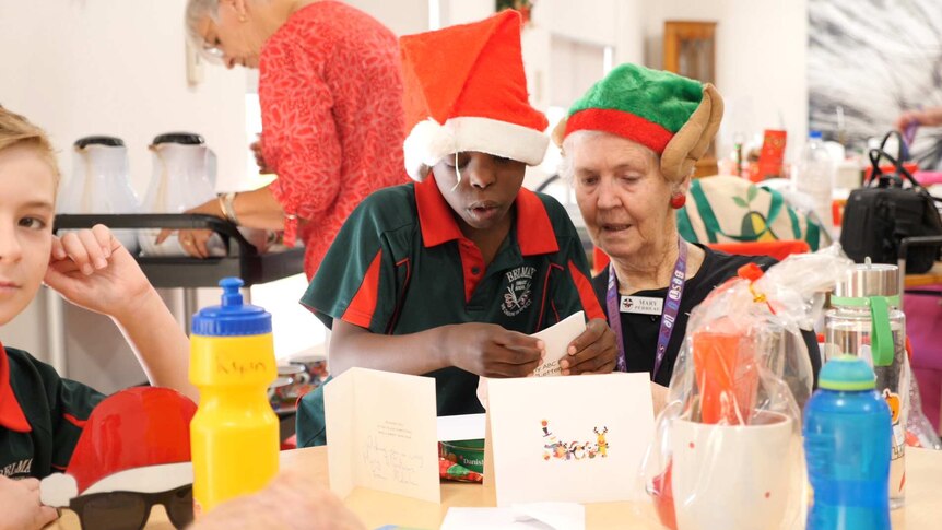 Children and residents exchange gifts and cards