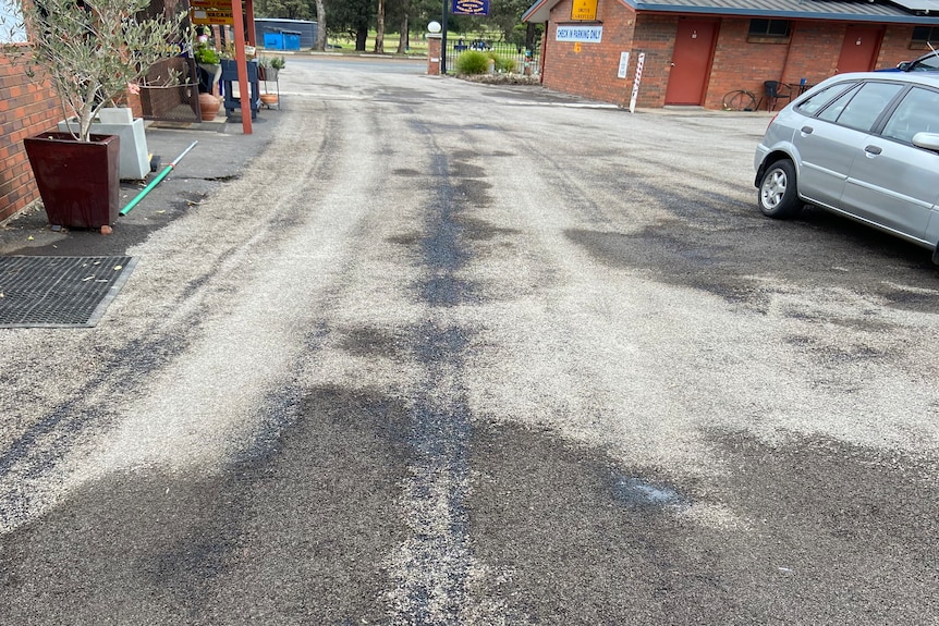 wide shot of carpark with loose gravel following bitumen resurfacing scam