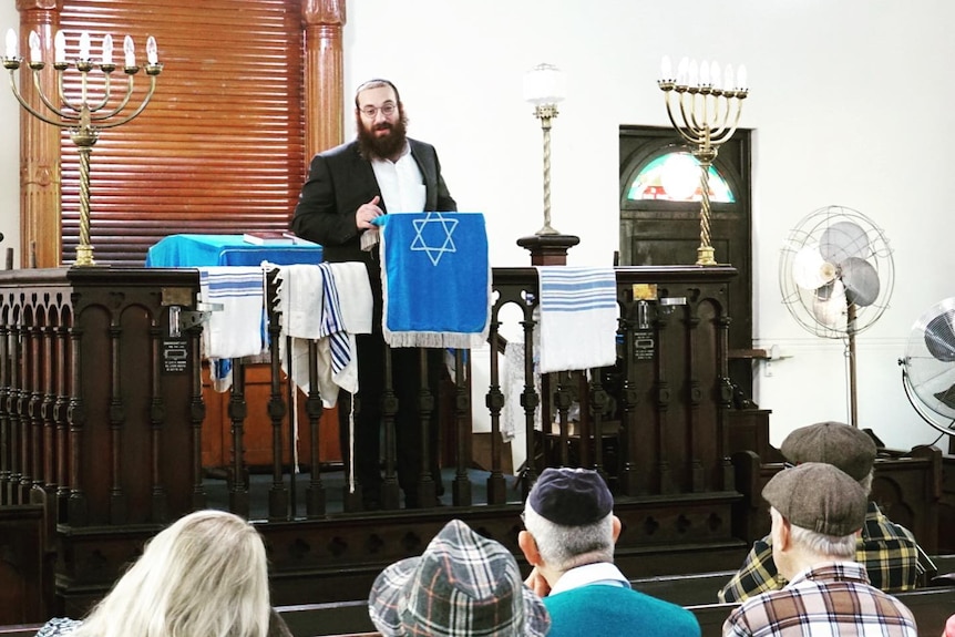 A rabbi speaking to a group of people