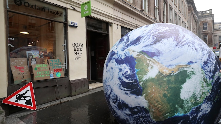 A giant globe is placed by campaigners outside an Oxfam shop