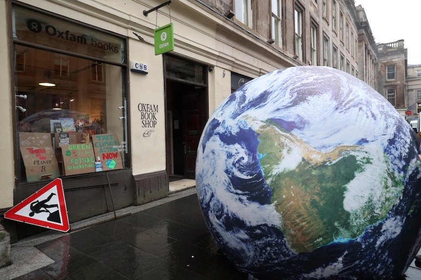 A giant globe is placed by campaigners outside an Oxfam shop