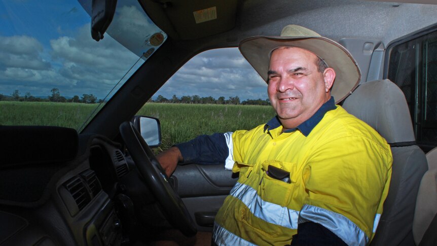 Greg sitting in his ute surrounded by sugar cane