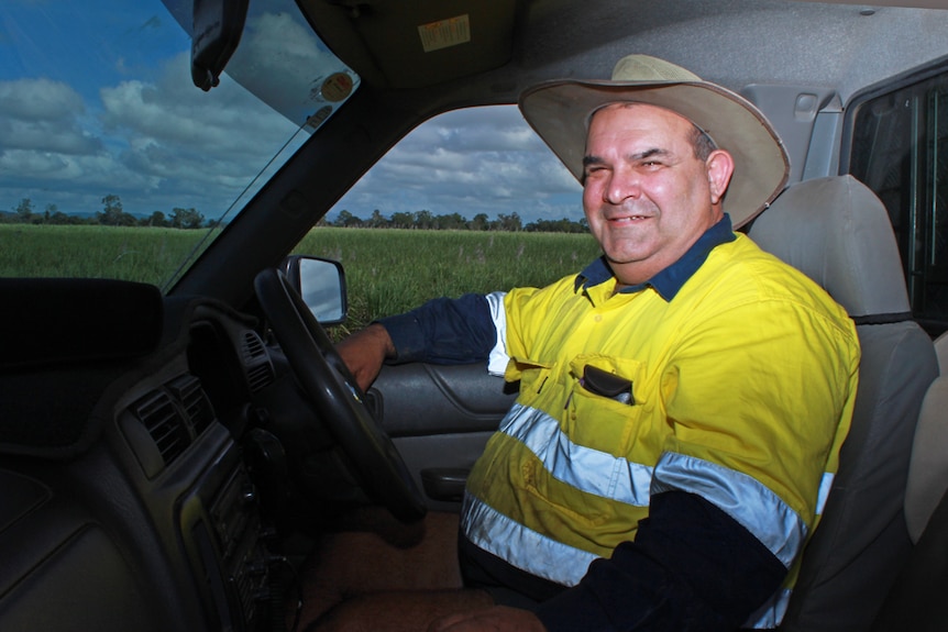 Greg sitting in his ute surrounded by sugar cane