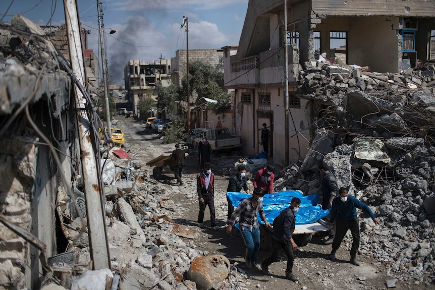 Residents carry the body of several people killed in airstrikes in Mosul during fighting between Iraq security forces.