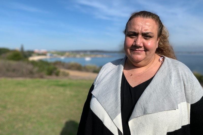 A woman standing at the shoreline.